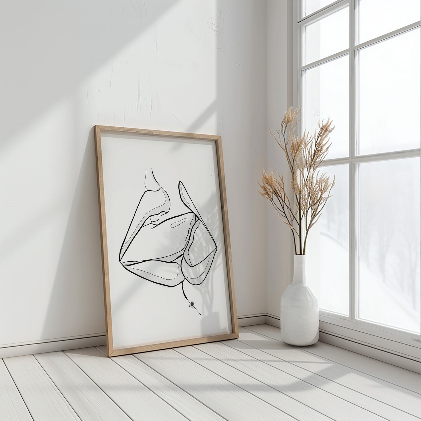 Mockup of downloadable erotic art of two mouths kissing. The erotica art is in a wooden frame, placed in a boho styled white room