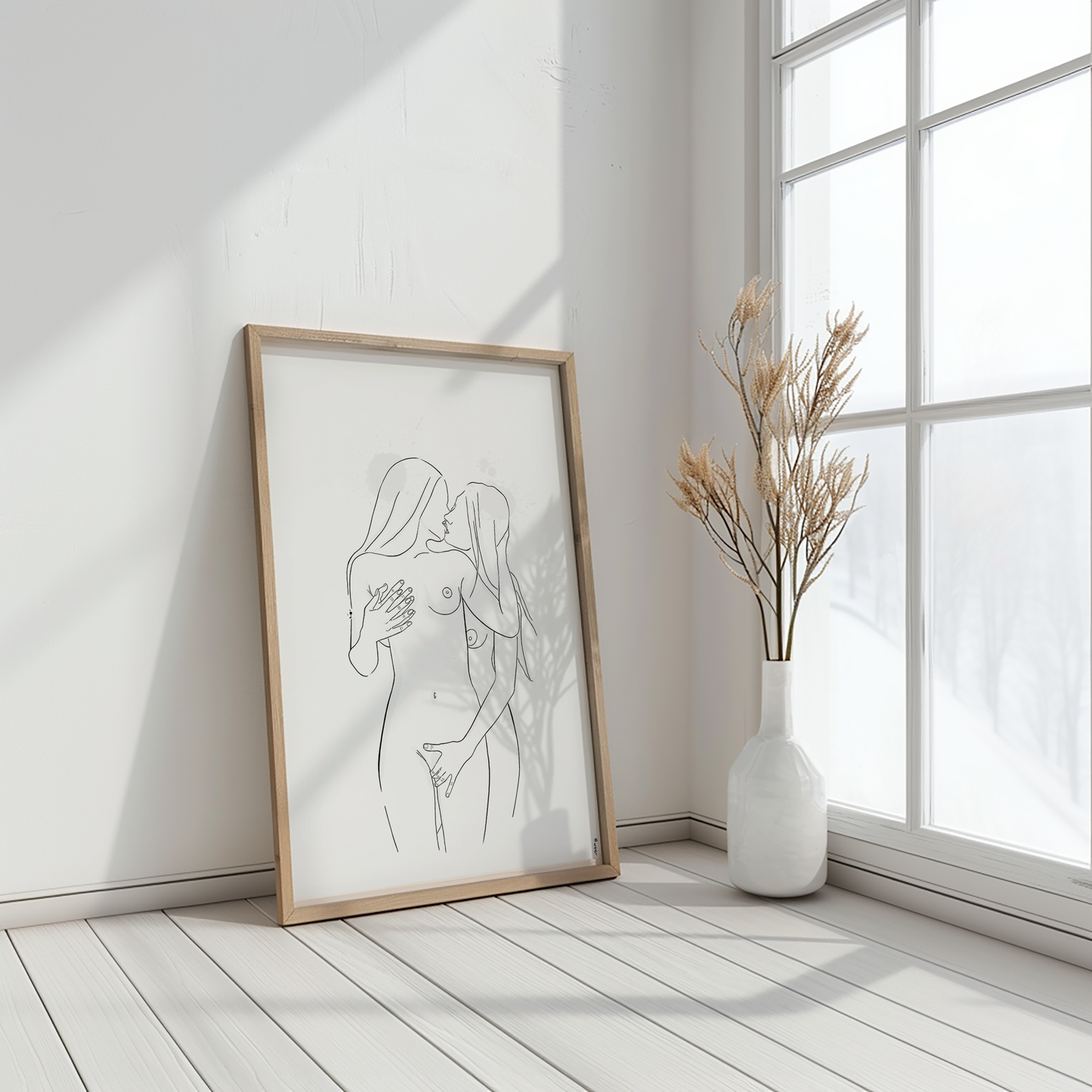 Mockup displaying erotic art of 2 nude women, in natural wooden frame on white floor near a big window