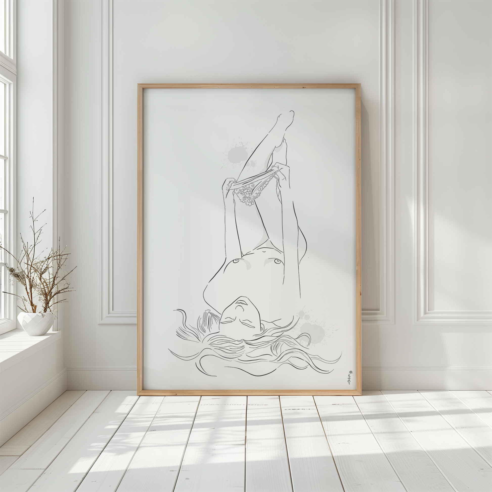 Mockup of an illustration of a nude woman undressing. This erotic art is placed in a wooden frame and leans against a white wall.