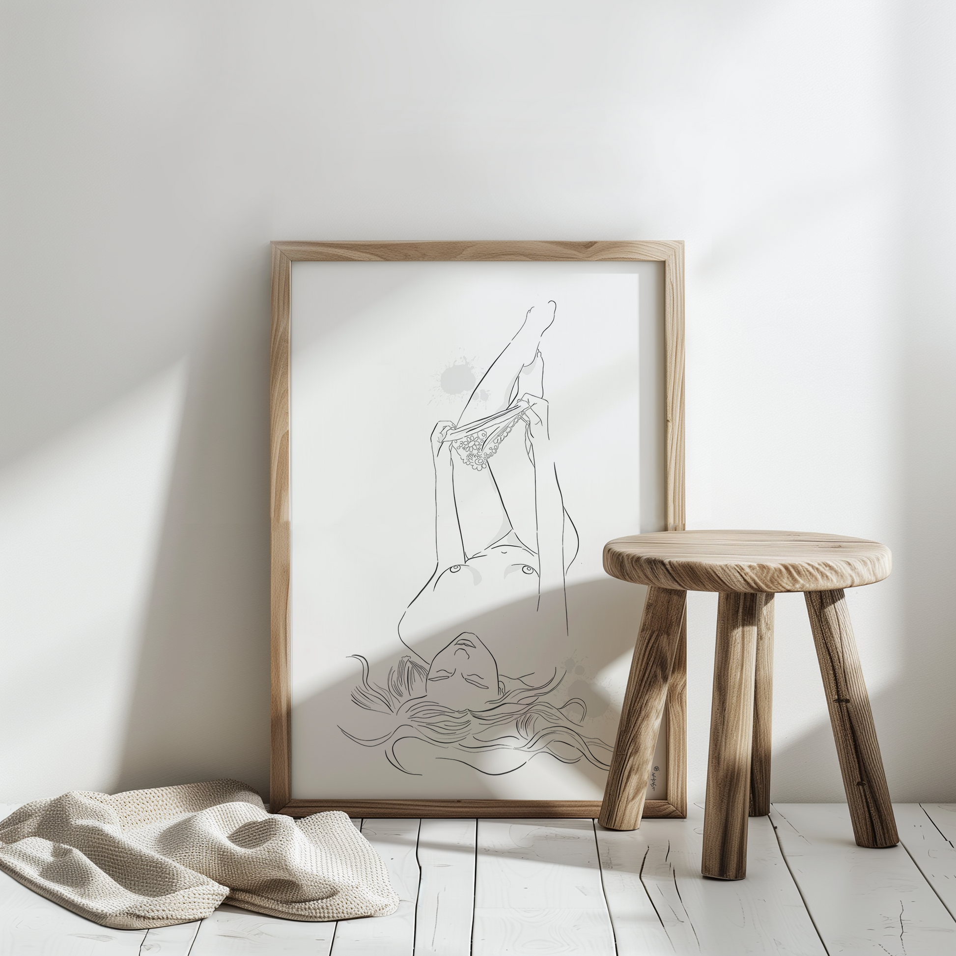 Mockup of an illustration of a nude woman undressing. This erotic art is placed in a natural color wooden frame and leans against a white wall on a white floor