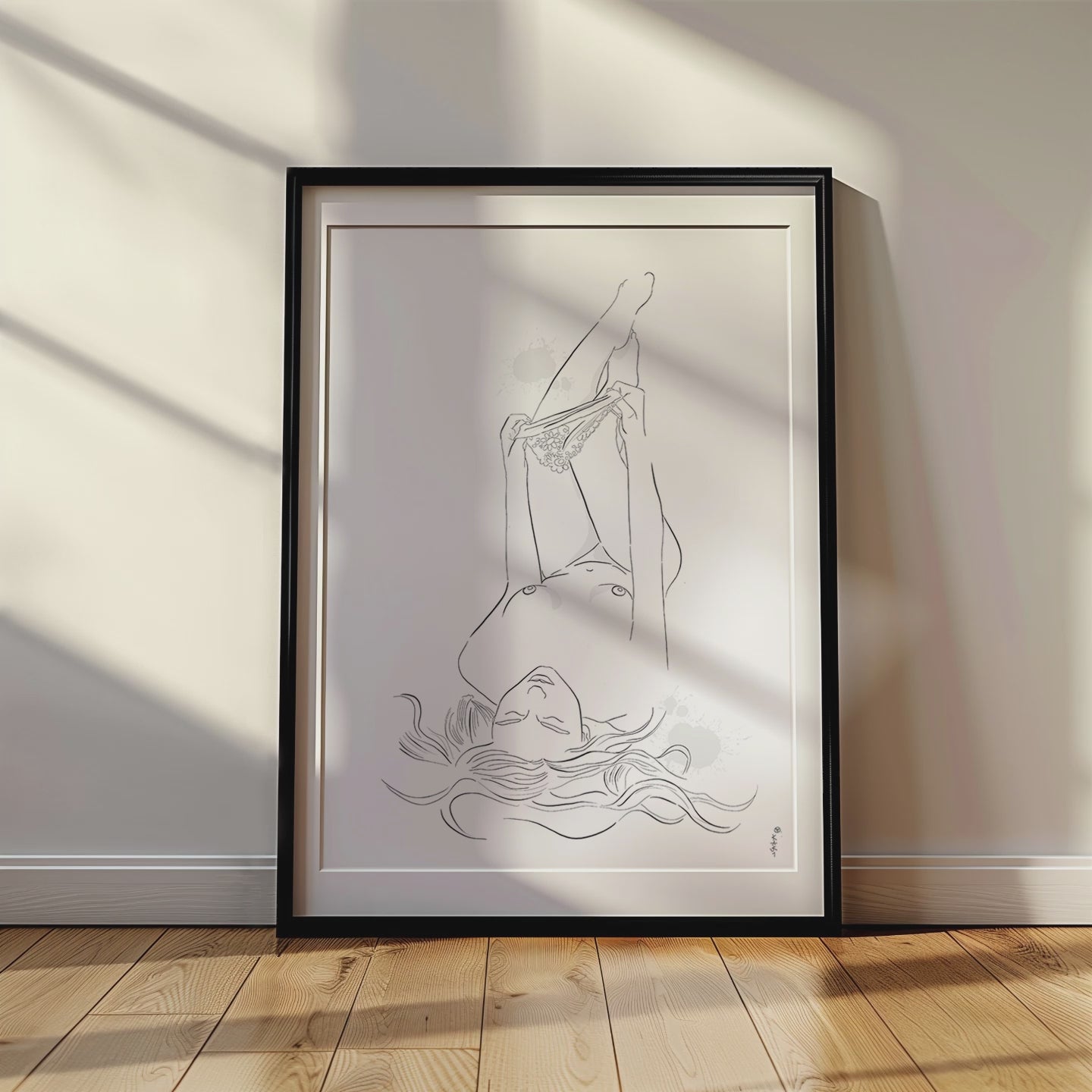 Video mockup of an illustration of a nude woman undressing. This erotic art is placed in a black frame and leans against a white wall on a wooden floor.