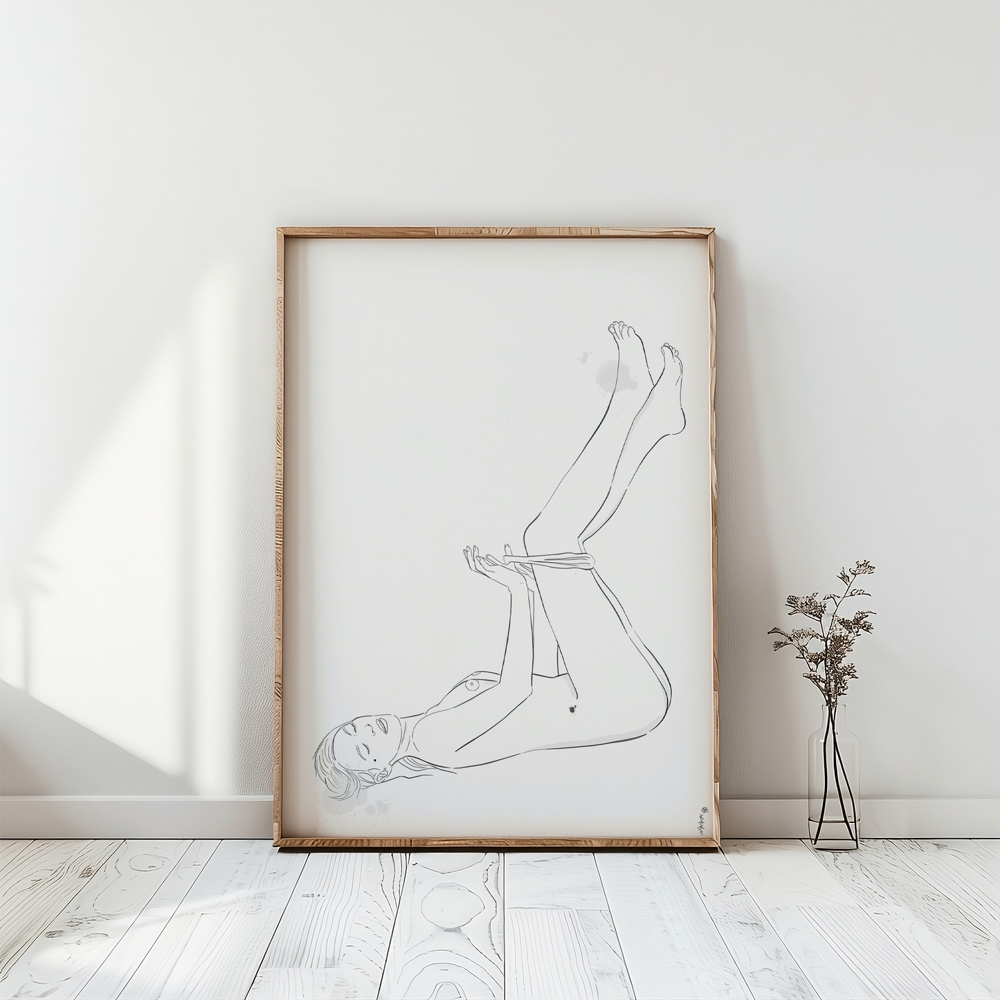 a nude female figure illustration placed in a frame. This erotic art is in a light room with a white wooden floor